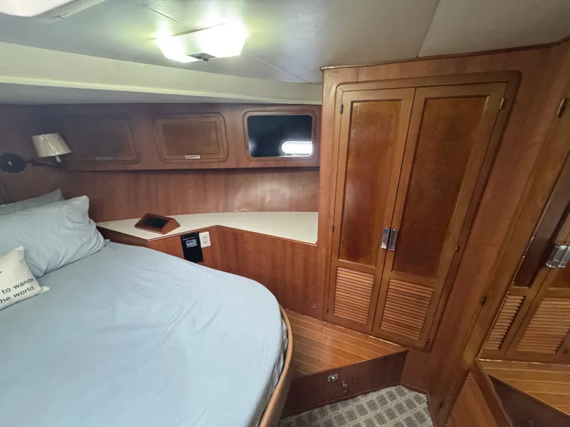 Slide: The Image of 1989 Ricker 48 Convertible yacht cabin with wooden interior and cozy bed. - 14