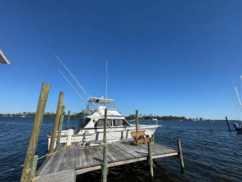 Slide: The Image of 1989 Ricker 48 Convertible yacht docked on a sunny day. - 17