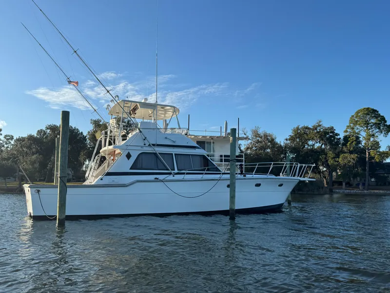 Slide: The Image of 1989 Ricker 48 Convertible yacht docked on calm water under clear blue sky. - 2