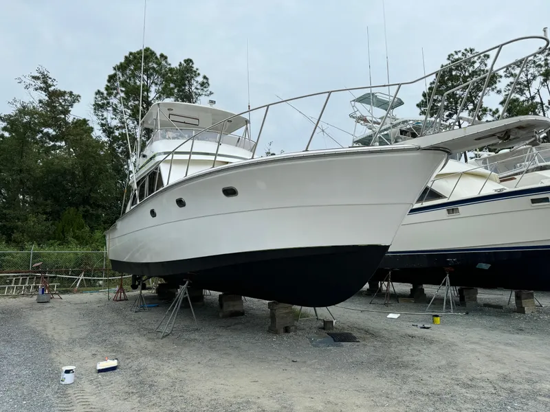 Slide: The Image of 1989 Ricker 48 Convertible yacht on dry dock, white hull, outdoor setting. - 20