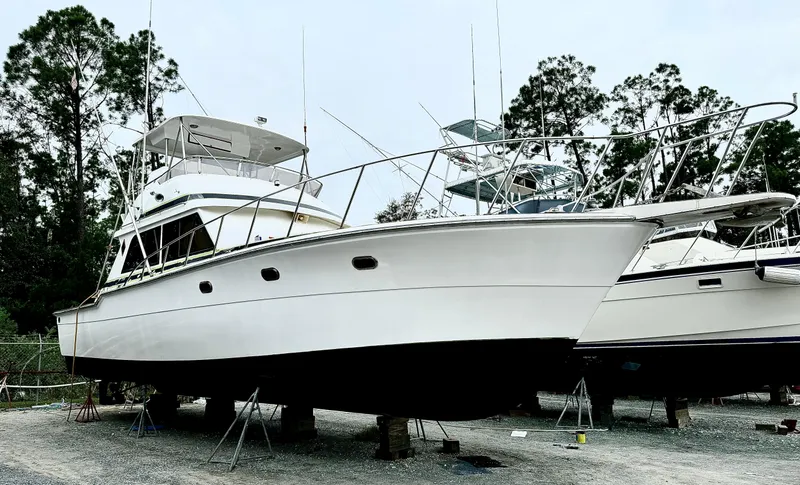 Slide: The Image of 1989 Ricker 48 Convertible yacht on dry dock, surrounded by trees. - 21