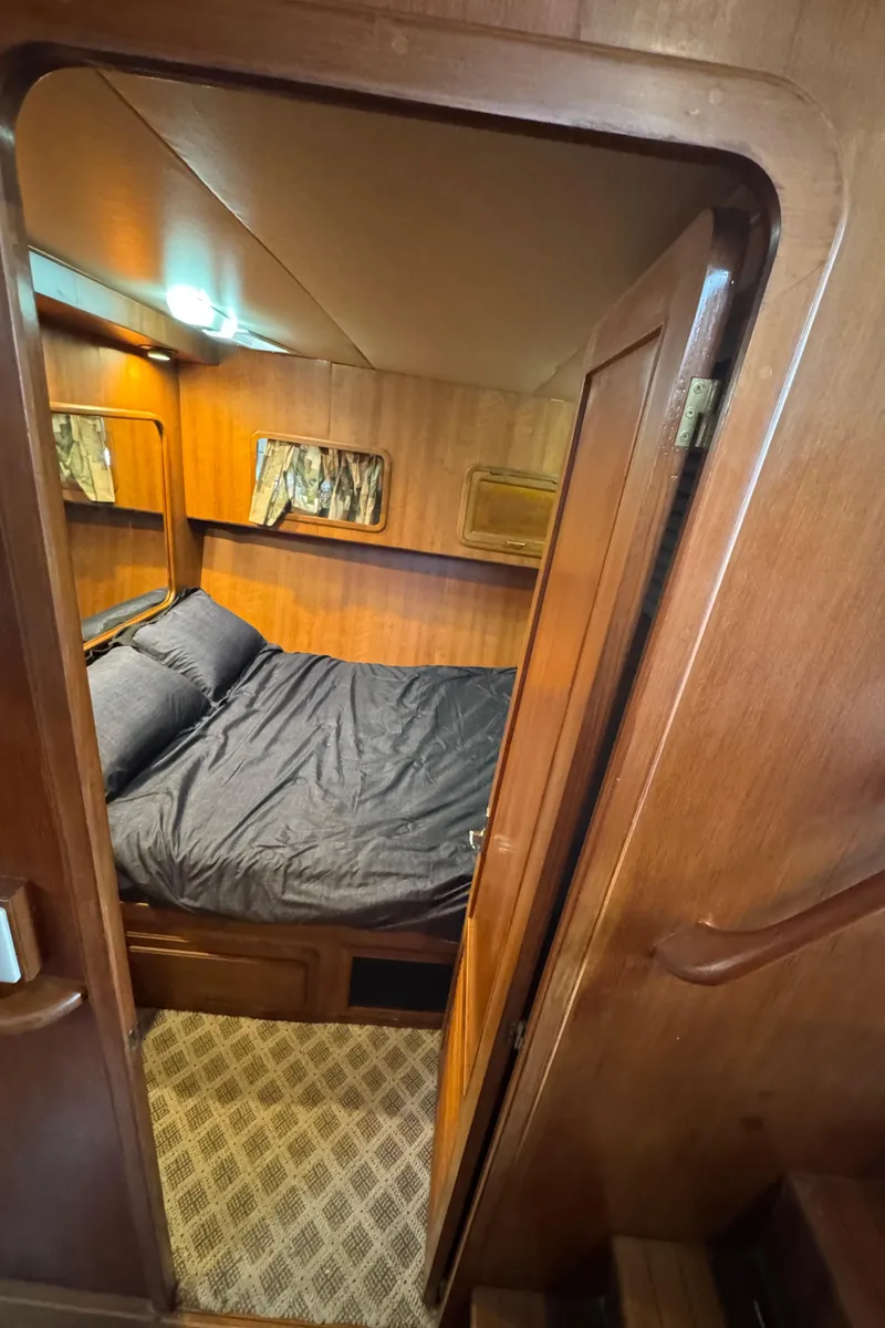 Slide: The Image of Cozy cabin interior of 1989 Ricker 48 Convertible yacht with wooden finish and bed. - 30