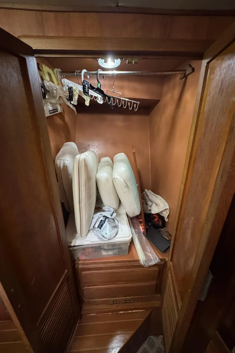 Slide: The Image of Wooden closet interior with cushions and storage in a 1989 Ricker 48 Convertible boat. - 33