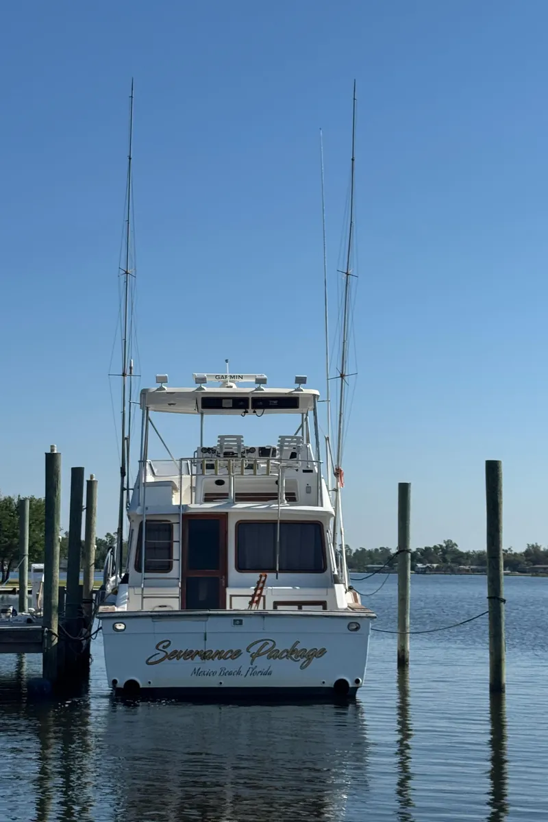 Slide: The Image of 1989 Ricker 48 Convertible yacht docked at marina under clear blue sky. - 35
