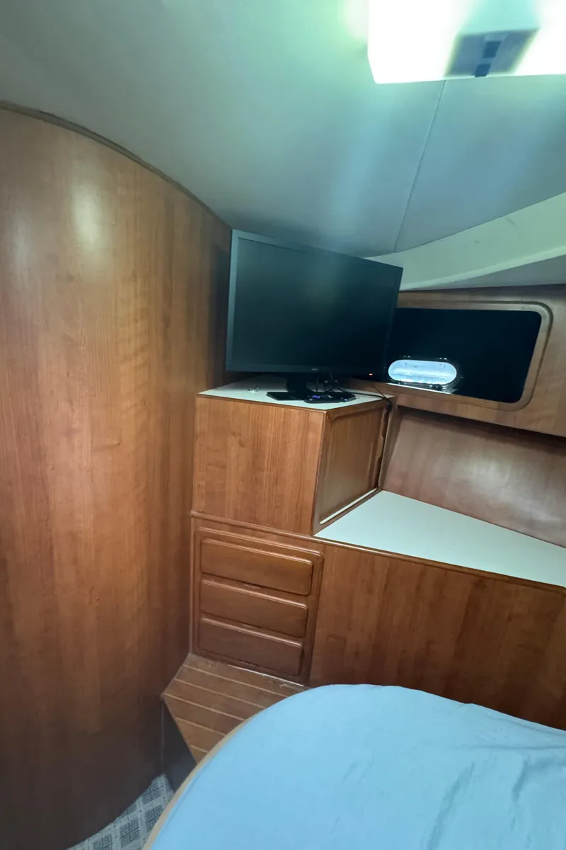 Slide: The Image of 1989 Ricker 48 Convertible yacht interior with TV and wooden cabinetry. - 37