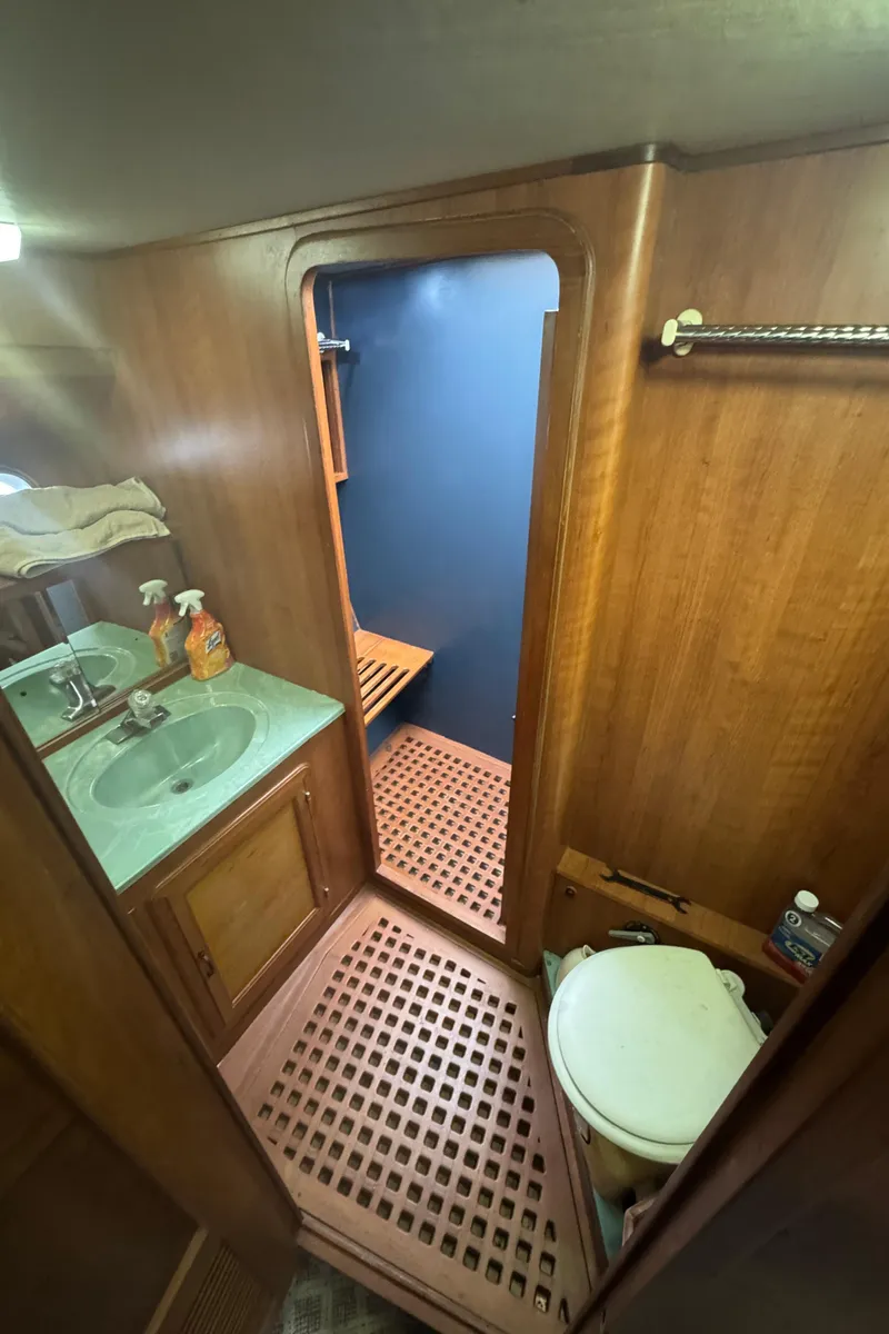 Slide: The Image of 1989 Ricker 48 Convertible yacht bathroom with wood paneling, sink, and shower area. - 39