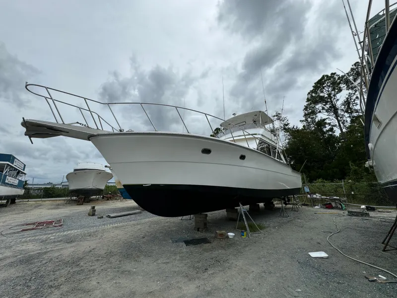 Slide: The Image of 1989 Ricker 48 Convertible yacht on dry dock, cloudy sky background. - 19