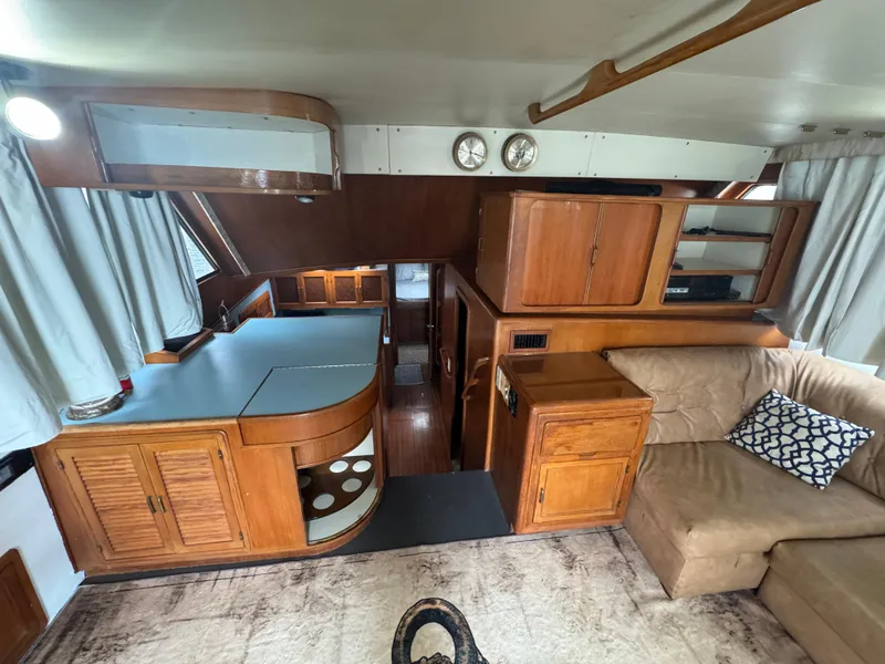 Slide: The Image of Interior of 1989 Ricker 48 Convertible yacht with wood cabinetry and beige sofa. - 7