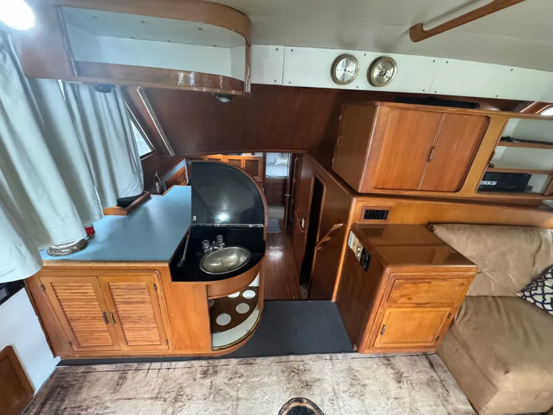 Slide: The Image of Interior of 1989 Ricker 48 Convertible yacht with wooden cabinetry and compact kitchen area. - 8