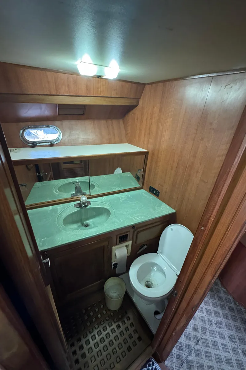 Slide: The Image of 1989 Ricker 48 Convertible yacht bathroom with wood paneling and compact design. - 31