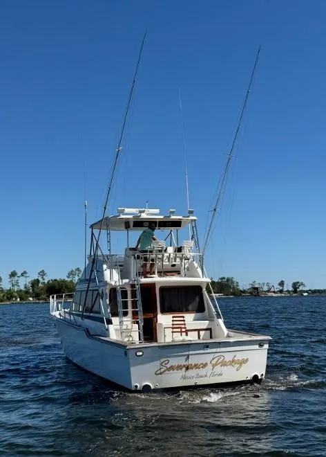 Slide: The Image of 1989 Ricker 48 Convertible yacht cruising on a sunny day with clear blue skies. - 28