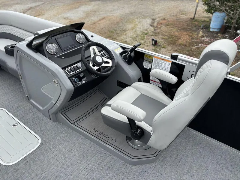 Slide: The Image of 2025 Godfrey Monaco 235 DFL boat cockpit with steering wheel and captain's chair. - 17