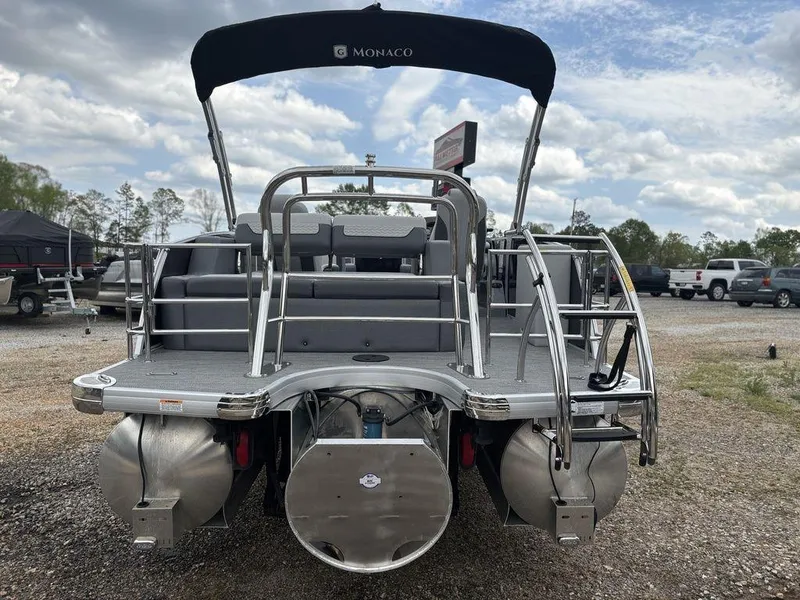 Slide: The Image of 2025 Godfrey Monaco 235 DFL pontoon boat, rear view, parked outdoors under cloudy sky. - 5