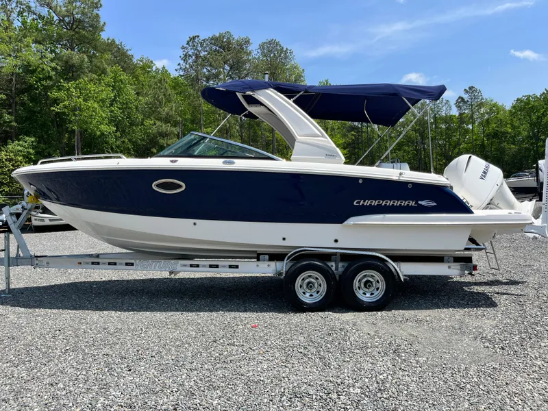 Slide: The Image of 2020 Chaparral 257 SSX boat on trailer, blue and white, parked outdoors. - 21