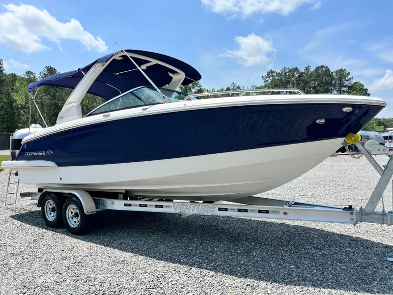 Slide: The Image of 2020 Chaparral 257 SSX boat on trailer, blue and white, parked outdoors. - 4