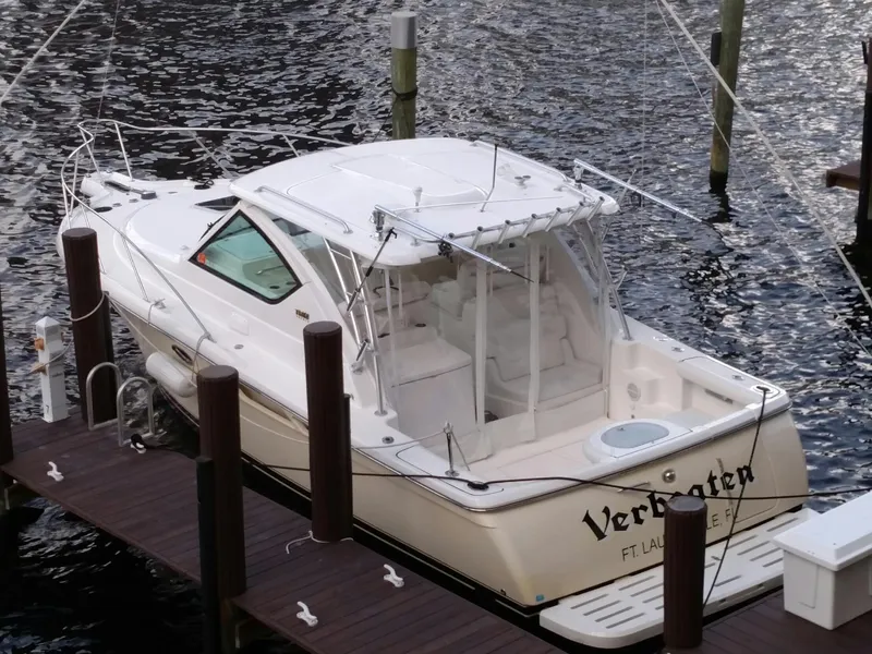 Slide: The Image of 2007 Tiara Yachts 3000 Open on lift, docked at marina under cloudy sky. - 3