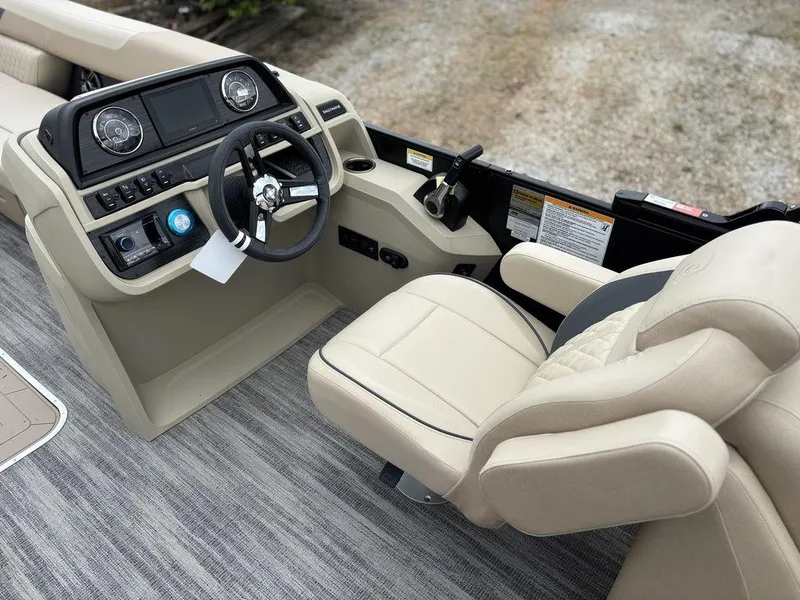 Slide: The Image of 2025 Godfrey SWEETWATER 2286 SB boat interior with beige captain's chair and control panel. - 17