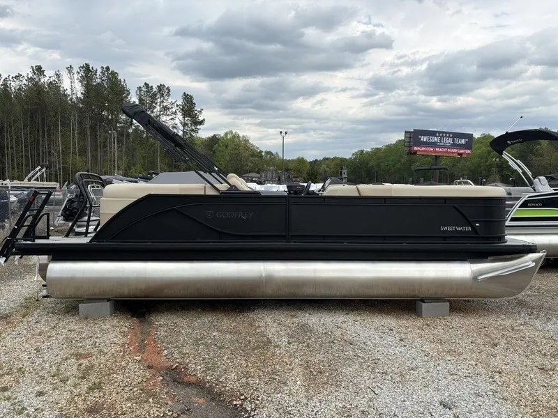 Slide: The Image of 2025 Godfrey SWEETWATER 2286 SB pontoon boat on gravel lot, overcast sky. - 5