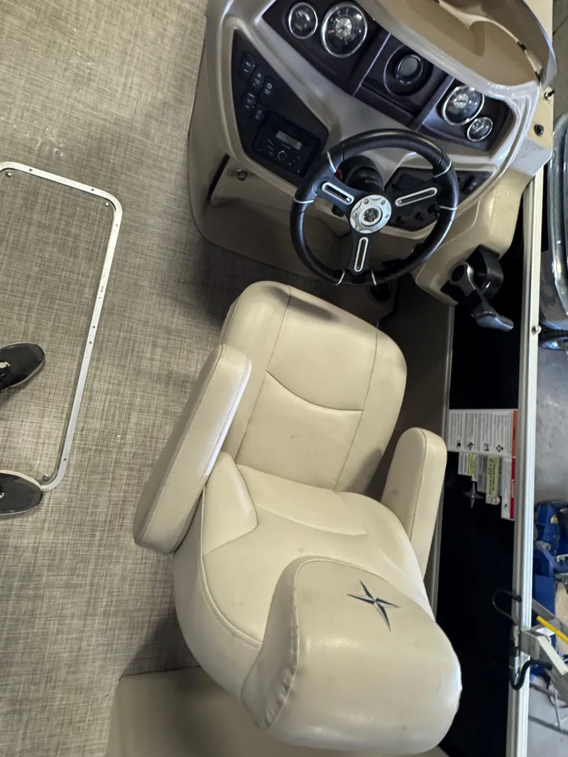 Slide: The Image of Captain's chair and dashboard of 2020 Berkshire 22RFX boat, featuring beige upholstery and steering wheel. - 10