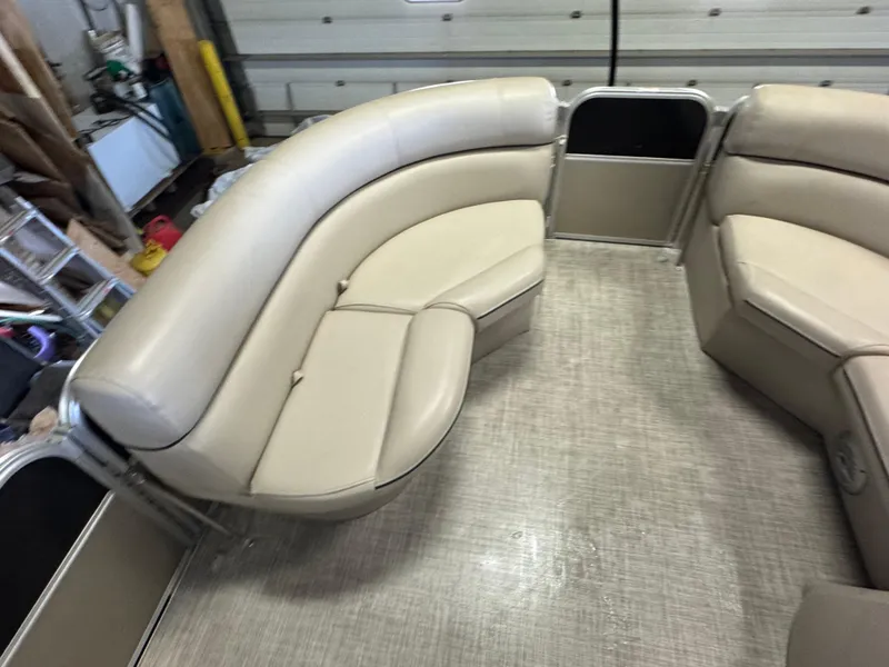 Slide: The Image of 2020 Berkshire 22RFX pontoon boat interior with beige seating in a garage setting. - 15