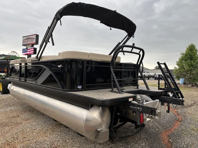 Slide: The Image of 2025 Godfrey Sweetwater 2086 C pontoon boat with canopy, parked on gravel. - 4