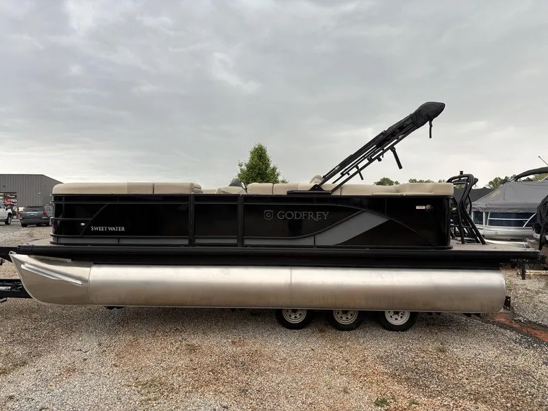 Slide: The Image of 2025 Godfrey Sweetwater 2086 C pontoon boat, black exterior, parked on gravel. - 5