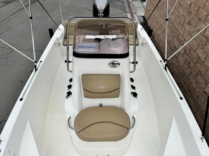 Slide: The Image of 2018 NauticStar 1910 boat interior with tan seating and console, featuring a 115 horsepower engine. - 10