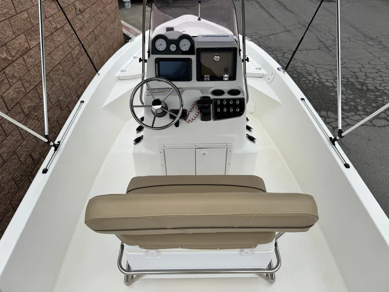 Slide: The Image of 2018 NauticStar 1910 boat interior with steering console and beige seating. - 11