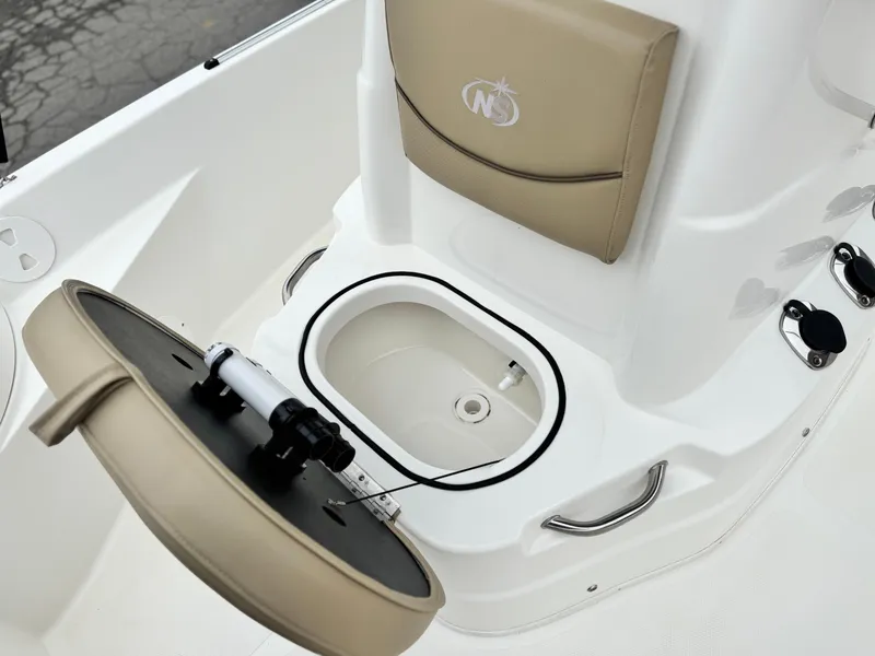 Slide: The Image of 2018 NauticStar 1910 boat interior with open storage compartment and beige seating. - 12
