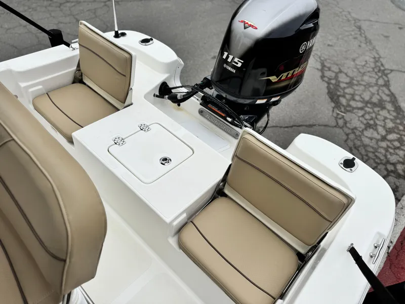 Slide: The Image of 2018 NauticStar 1910 boat interior with Yamaha 115 engine, featuring beige seating and storage. - 14