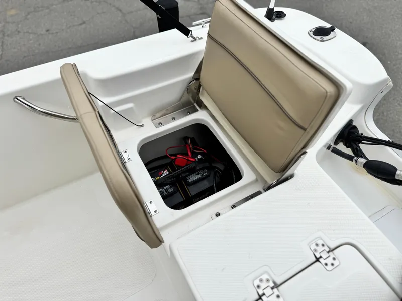 Slide: The Image of 2018 NauticStar 1910 boat with open storage compartment revealing battery and cables. - 16