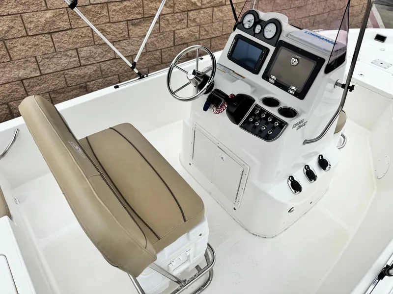 Slide: The Image of 2018 NauticStar 1910 boat console with steering wheel and beige seating. - 17