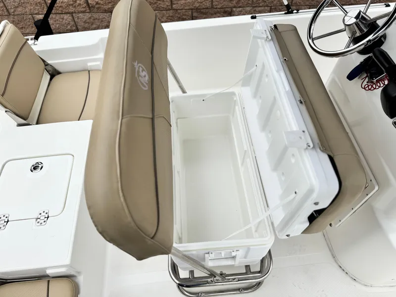 Slide: The Image of 2018 NauticStar 1910 boat interior with open storage compartment and beige seating. - 18
