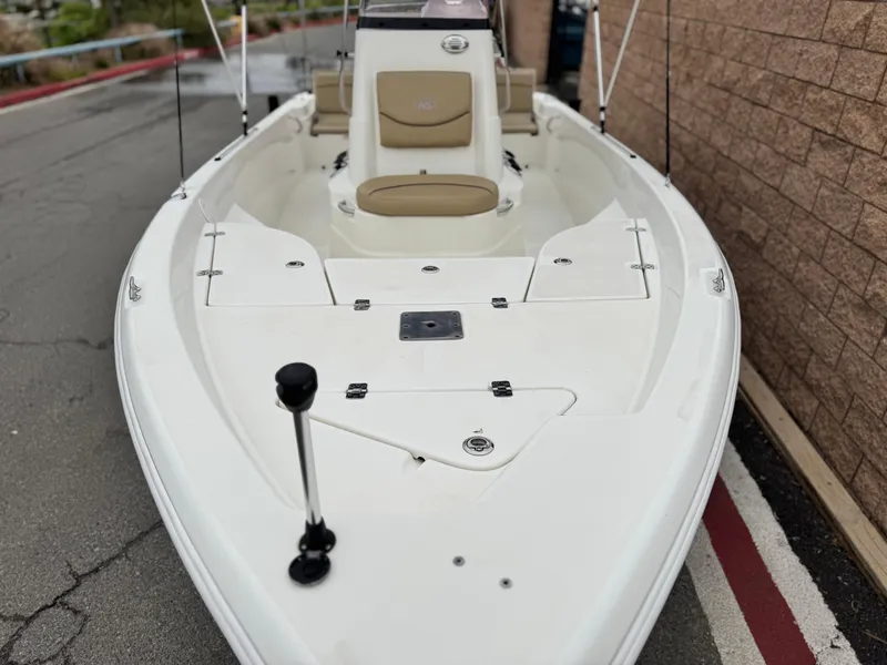 Slide: The Image of 2018 NauticStar 1910 boat with beige seating, docked near a brick wall. - 6