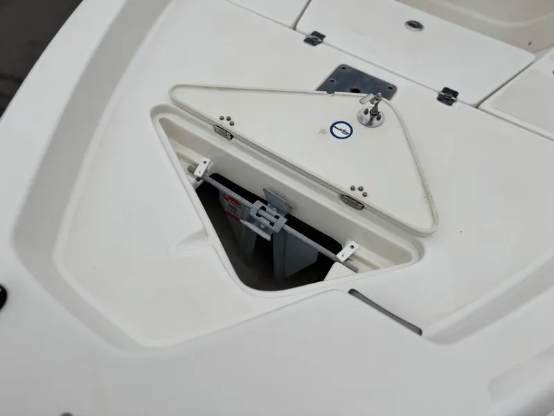 Slide: The Image of 2018 NauticStar 1910 boat anchor compartment, open and empty, with white interior. - 9