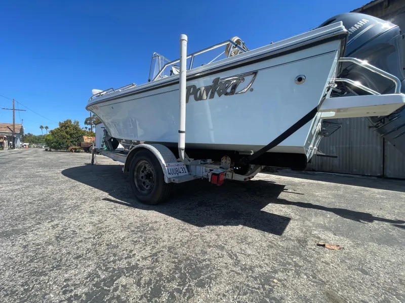 Slide: The Image of 2017 Parker 1801 CC boat on trailer, parked outdoors under clear blue sky. - 17