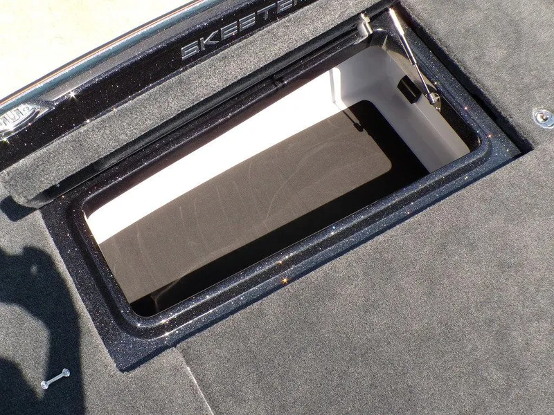 Slide: The Image of 2025 Skeeter ZXR19 boat storage compartment with open lid, showcasing interior space. - 12