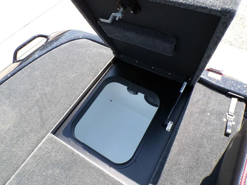 Slide: The Image of Open storage compartment in 2025 Skeeter ZXR19 boat, featuring a carpeted interior. - 2