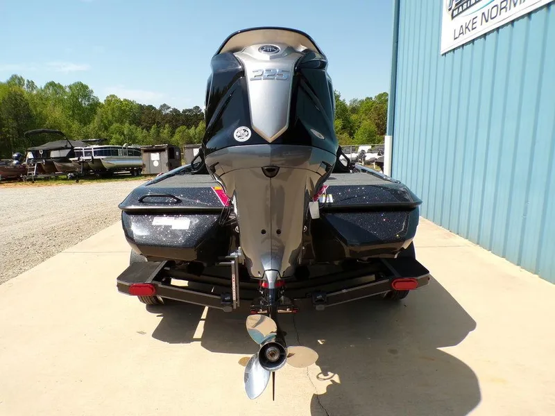 Slide: The Image of 2025 Skeeter ZXR19 boat rear view with outboard motor, parked on concrete. - 21