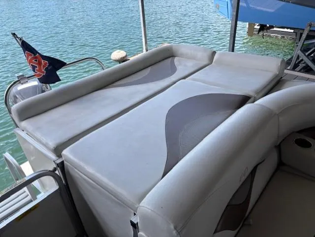 Slide: The Image of 2007 Avalon Windjammer RC boat with cushioned seating, docked by the water. - 11