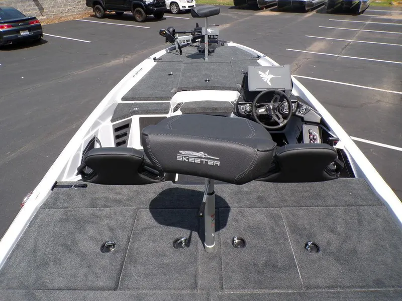 Slide: The Image of 2025 Skeeter ZXR19 boat interior with steering wheel and seating in a parking lot. - 14