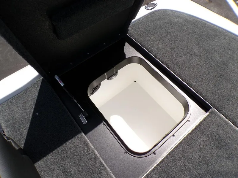 Slide: The Image of Open storage compartment in 2025 Skeeter ZXR19 boat, featuring carpeted interior. - 2