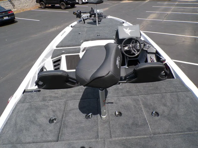Slide: The Image of 2025 Skeeter ZXR19 boat interior with gray carpet and black seating in a parking lot. - 4