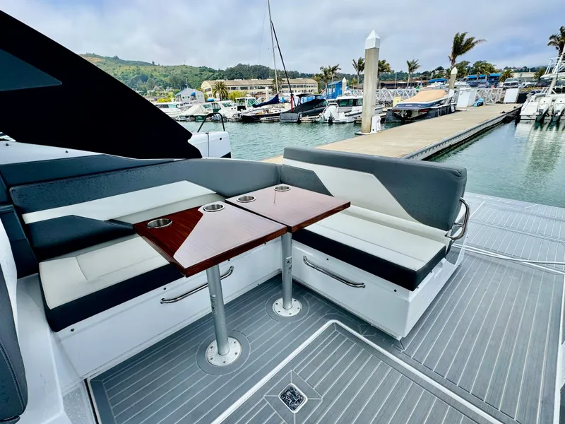 Slide: The Image of 2023 Cruisers Yachts 34 GLS I/O with sleek seating and table, docked at marina. - 23