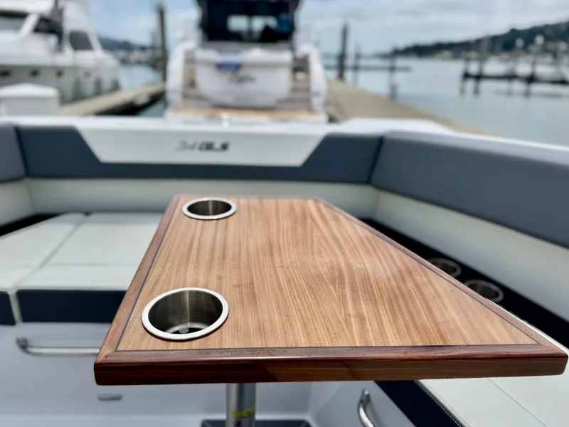 Slide: The Image of 2023 Cruisers Yachts 34 GLS I/O boat interior with wooden table and cup holders. - 37