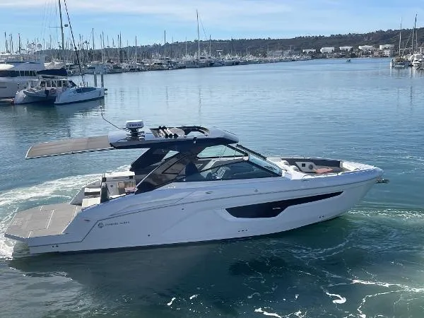 Slide: The Image of 2023 Cruisers Yachts 34 GLS I/O in marina, sleek design, calm waters, sunny day. - 2