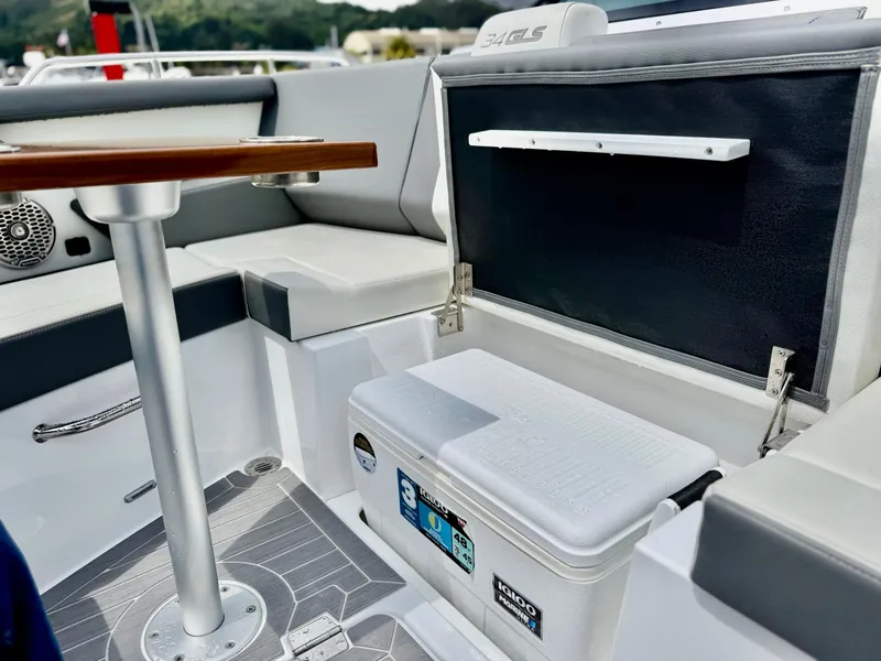 Slide: The Image of 2023 Cruisers Yachts 34 GLS I/O interior with seating, table, and cooler. - 37