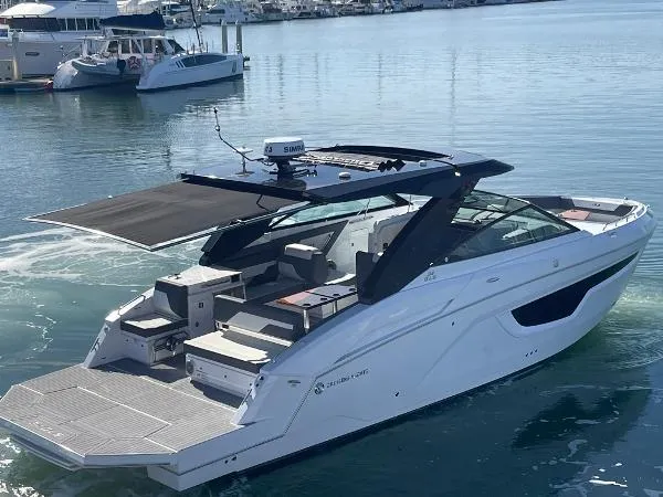 Slide: The Image of 2023 Cruisers Yachts 34 GLS I/O luxury boat on calm water, featuring sleek design and spacious deck. - 4