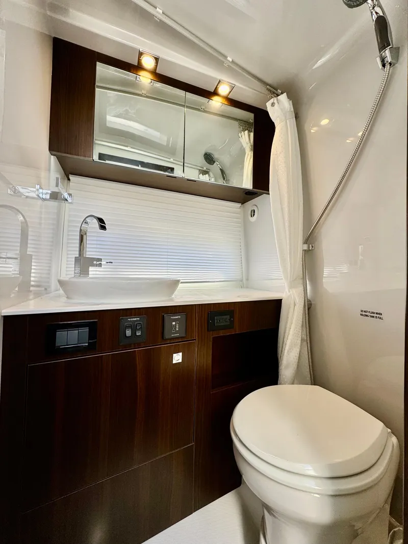 Slide: The Image of 2023 Cruisers Yachts 34 GLS I/O bathroom with modern fixtures and elegant wood cabinetry. - 47