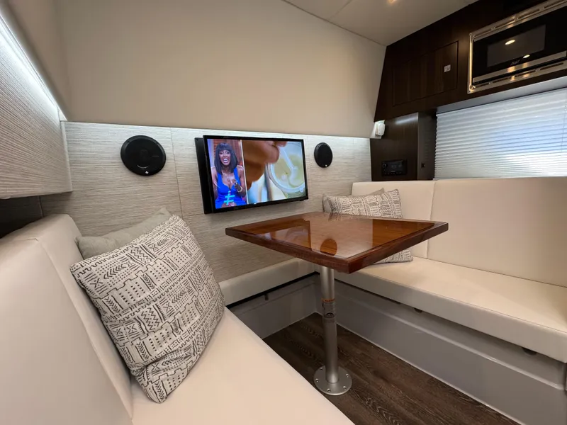 Slide: The Image of 2023 Cruisers Yachts 34 GLS I/O interior with TV, seating, and table. - 48